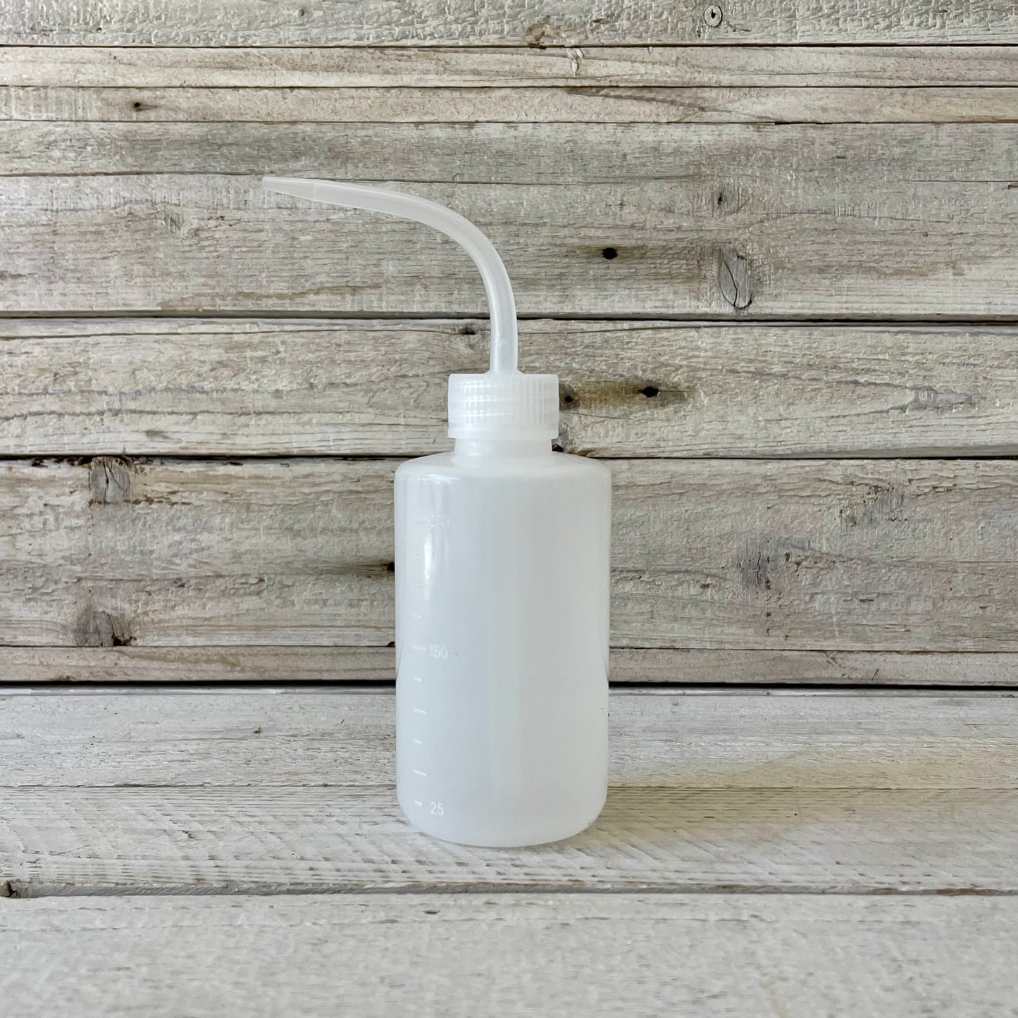 A semi opaque, soft plastic squeeze bottle with a tapered nozzle, designed for precision watering. Ideal for reaching tight spaces between succulents and ensuring direct hydration to the soil while keeping delicate leaves dry.